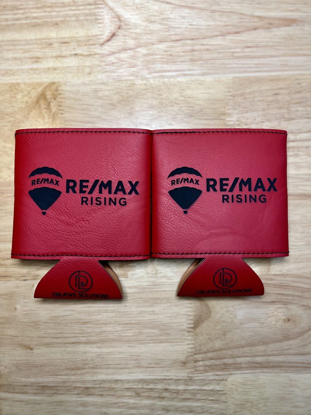 Two red custom RE/MAX Rising leather can coolers